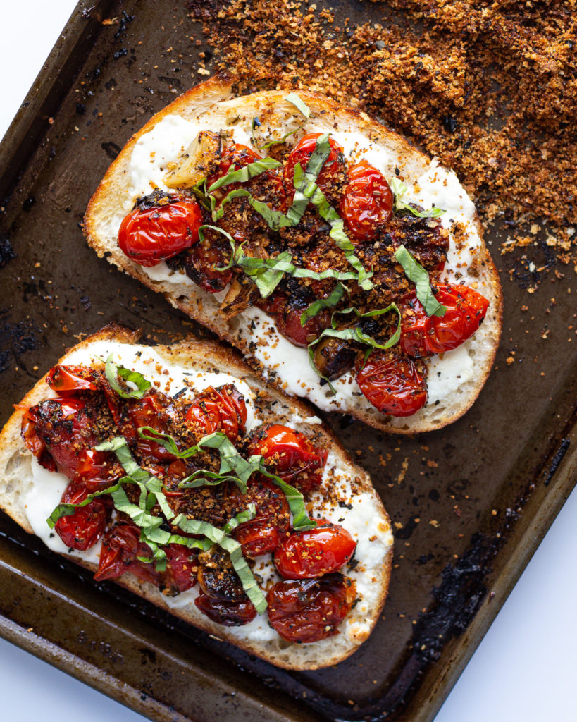 blistered tomatoes and burrata toast with breadcrumbs on top
