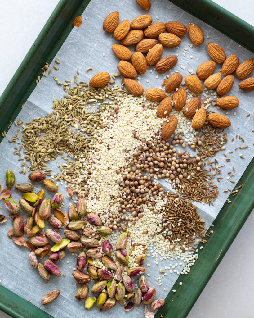 Almonds, pistachios and seasonings on baking sheet