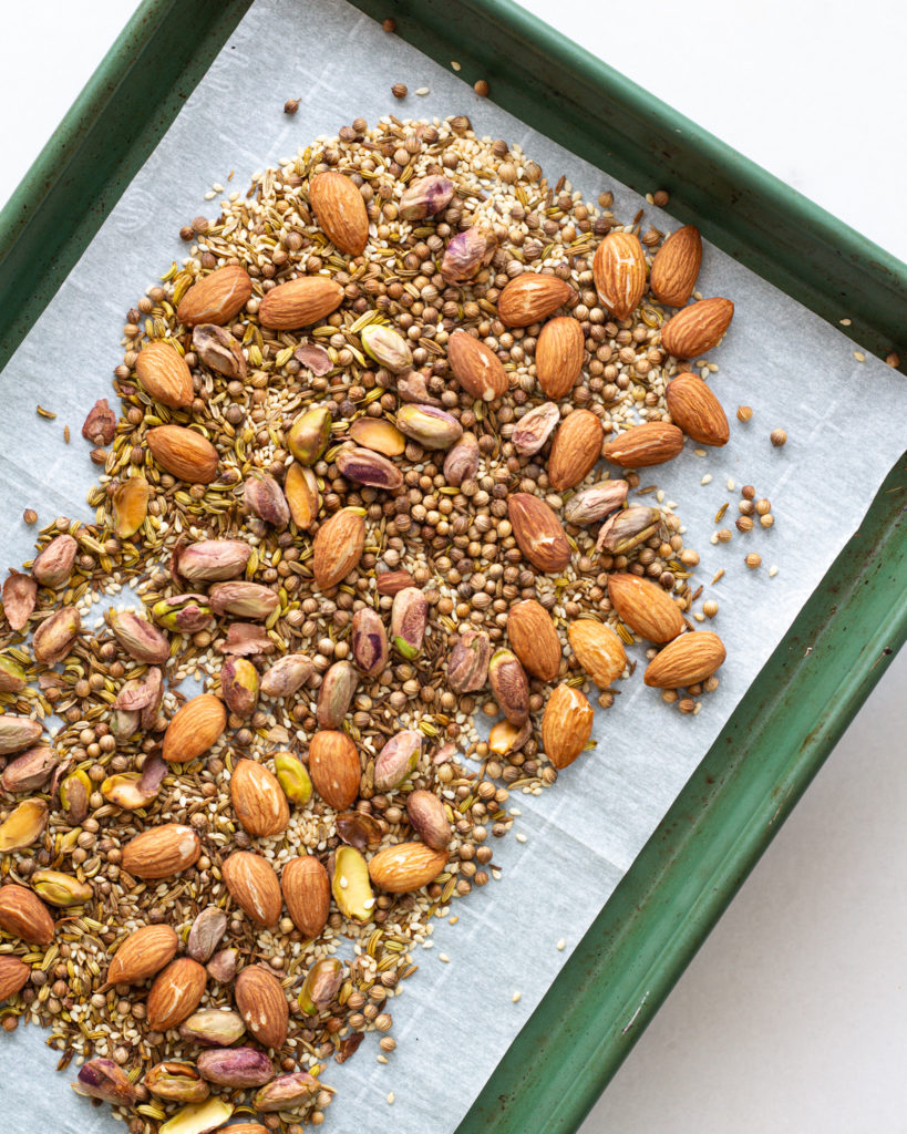 Almonds, pistachios and seasonings on baking sheet