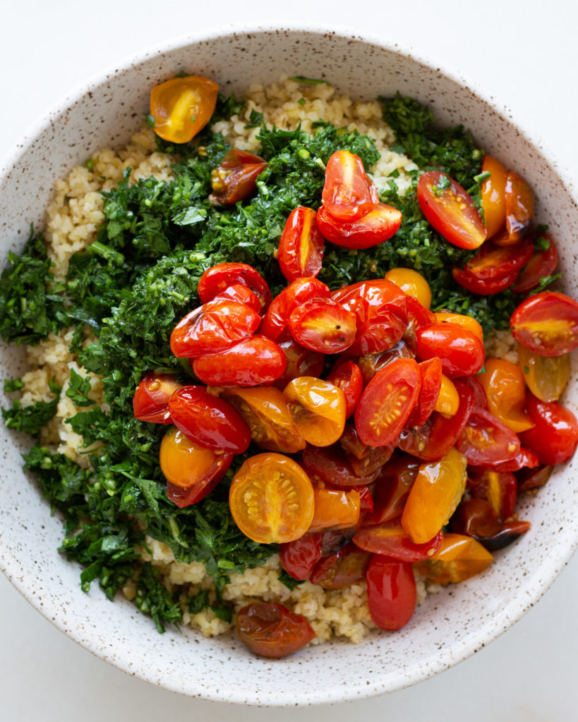 Bulgar wheat, parsley mixture and tomatoes added to bowl