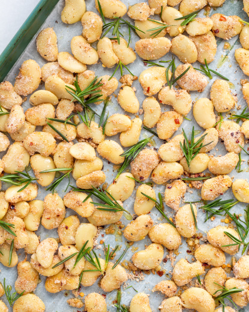 Floured beans on baking sheet with fresh rosemary