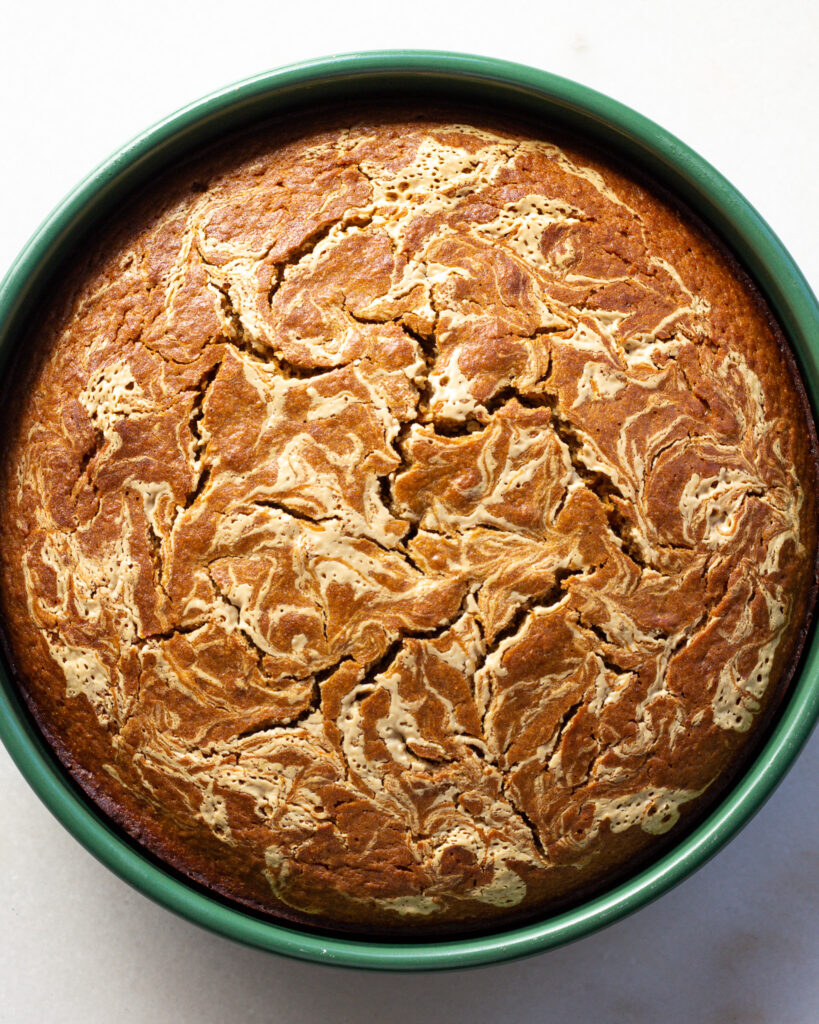 Tamarind carrot cake with tahini swirl in a round baking dish