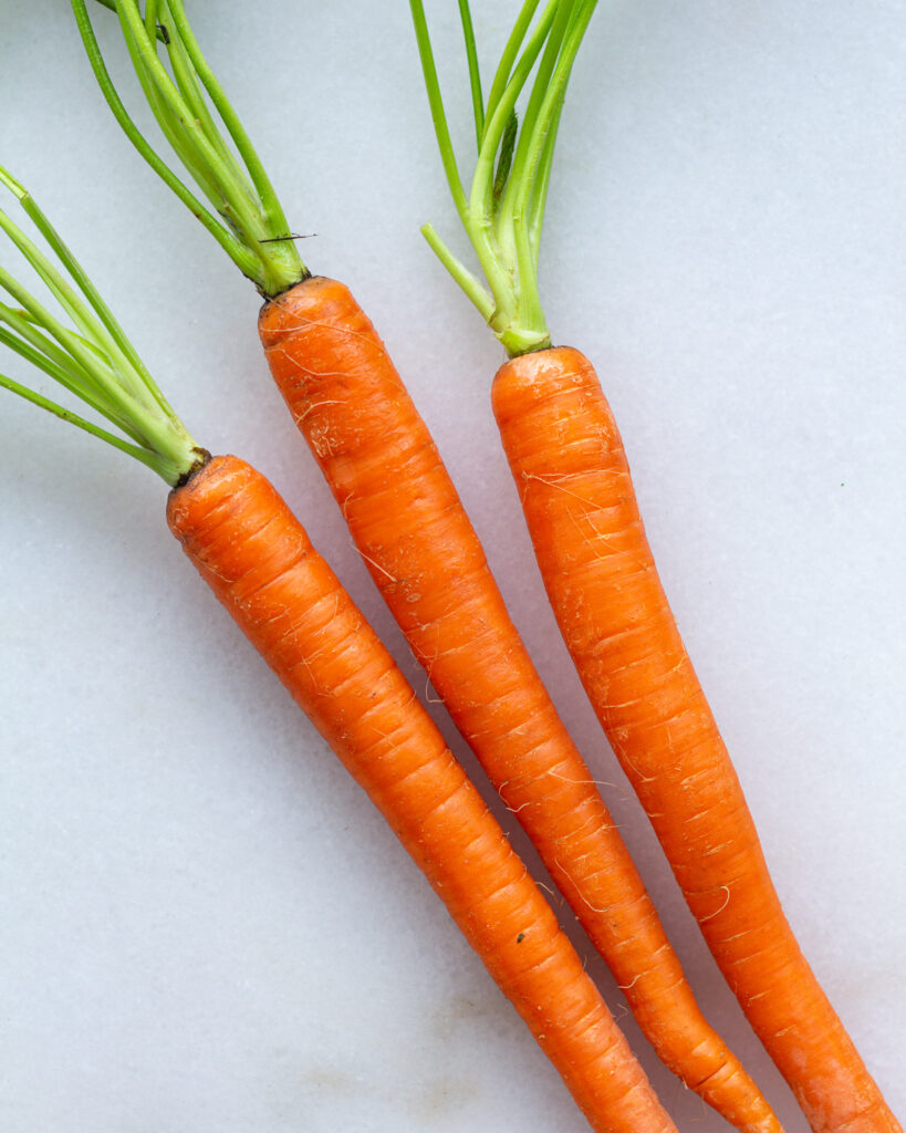 three carrots with green tops 