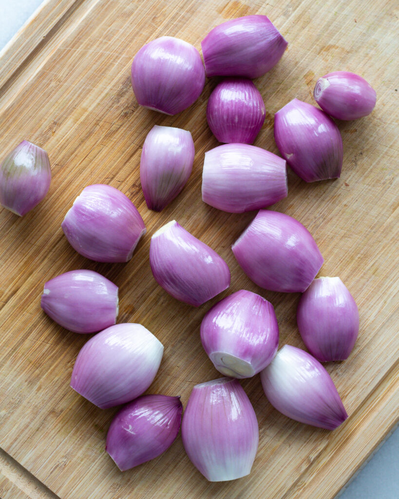Peeled shallots on a cutting board