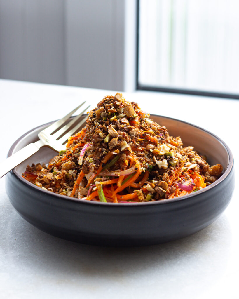 the carrot salad in a bowl from a side angle 