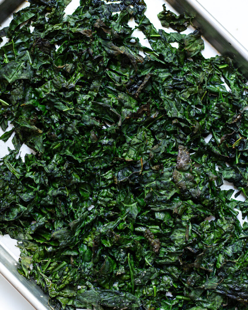 Baked kale on a sheet tray for a baked salad