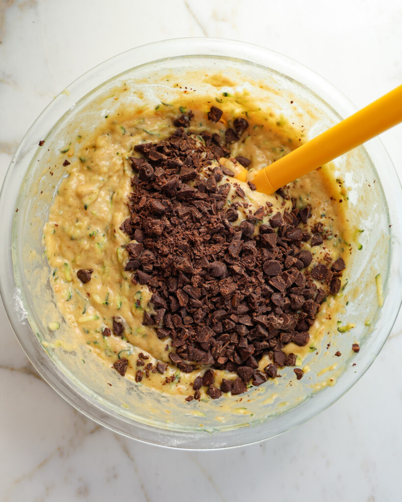 the brown butter zucchini loaf batter with chocolate just added, in a bowl about to be mixed