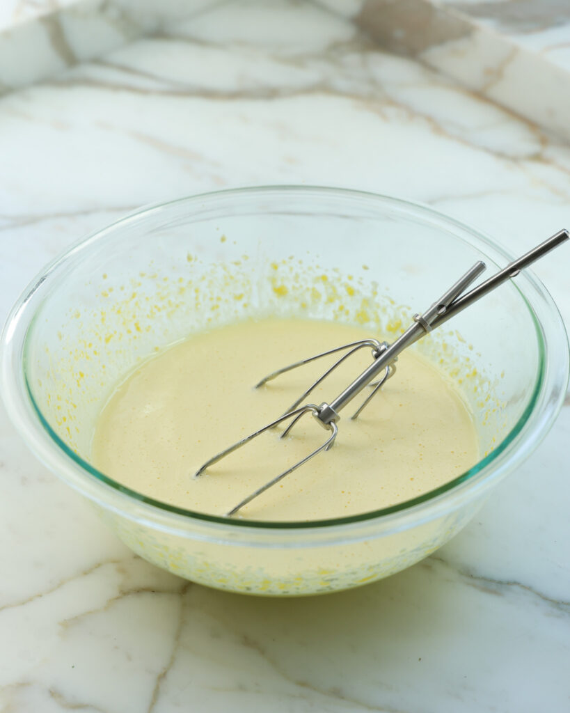 whisking together egg yolks for an ice cream base