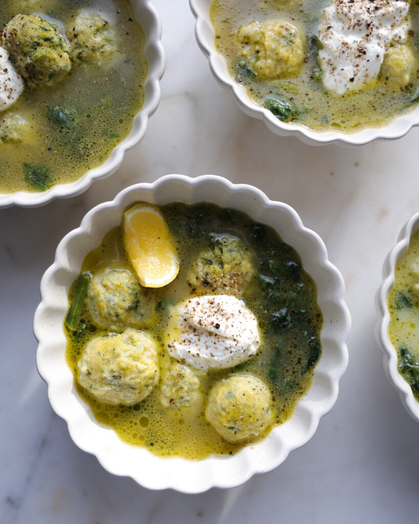 Three bowls of Spinach Gnudi in Parmesan Broth being served