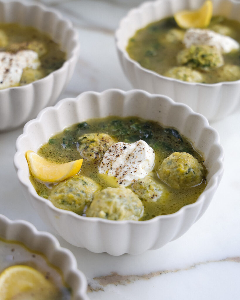 Plated example of Spinach Gnudi in Parmesan Broth