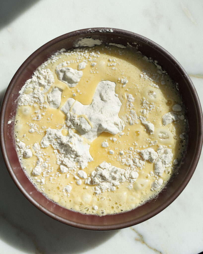 Egg, water and flour to make spaetzle in a bowl.