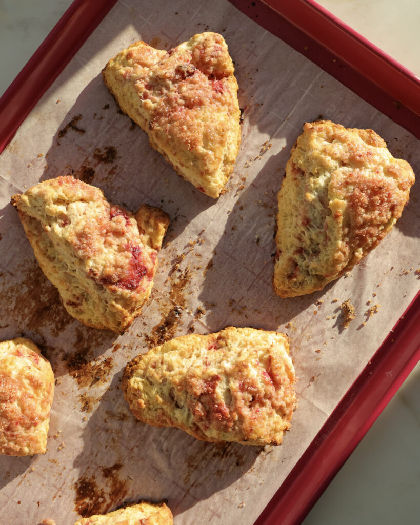 strawberry raspberry scones on a baking sheet.