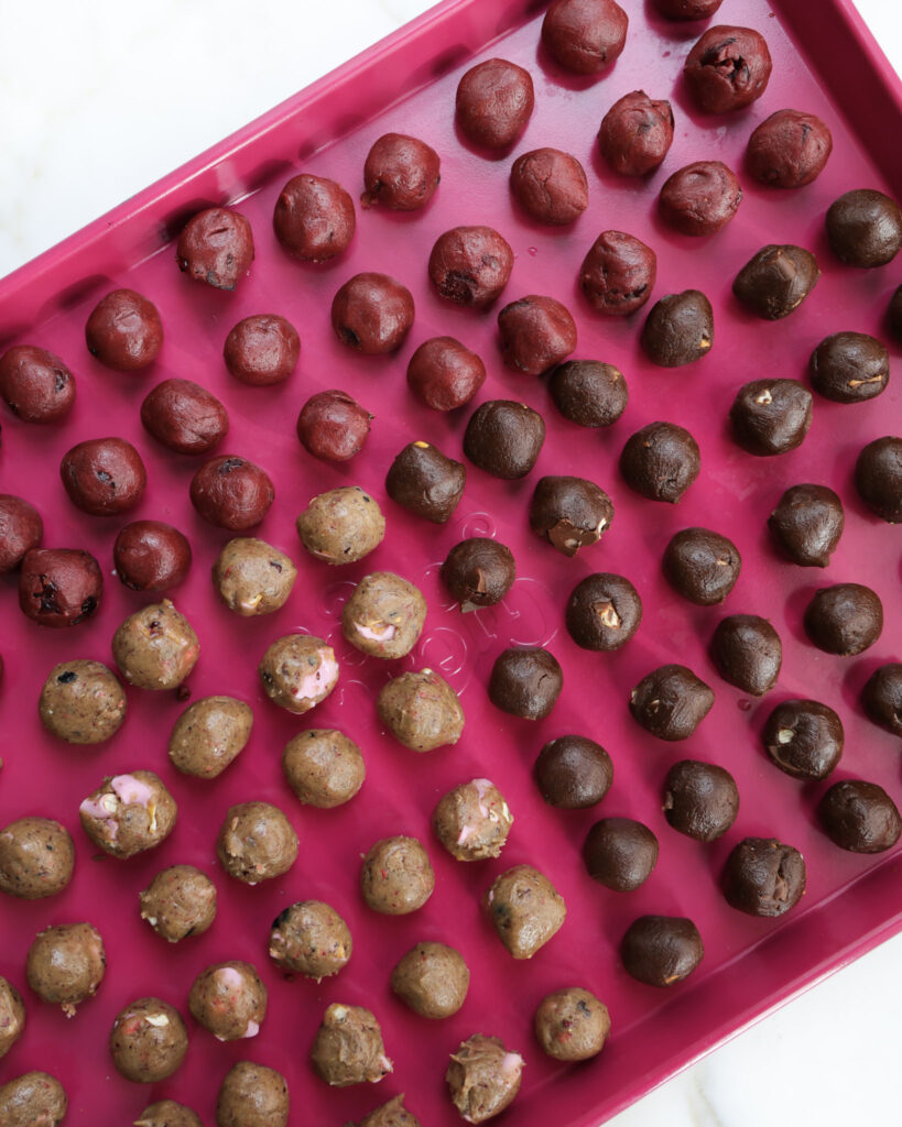 small dough balls of cookie dough ready to be rolled up into marbled dough