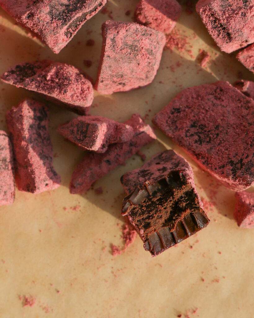 strawberry latte chocolate truffles with a bite taken out of it.