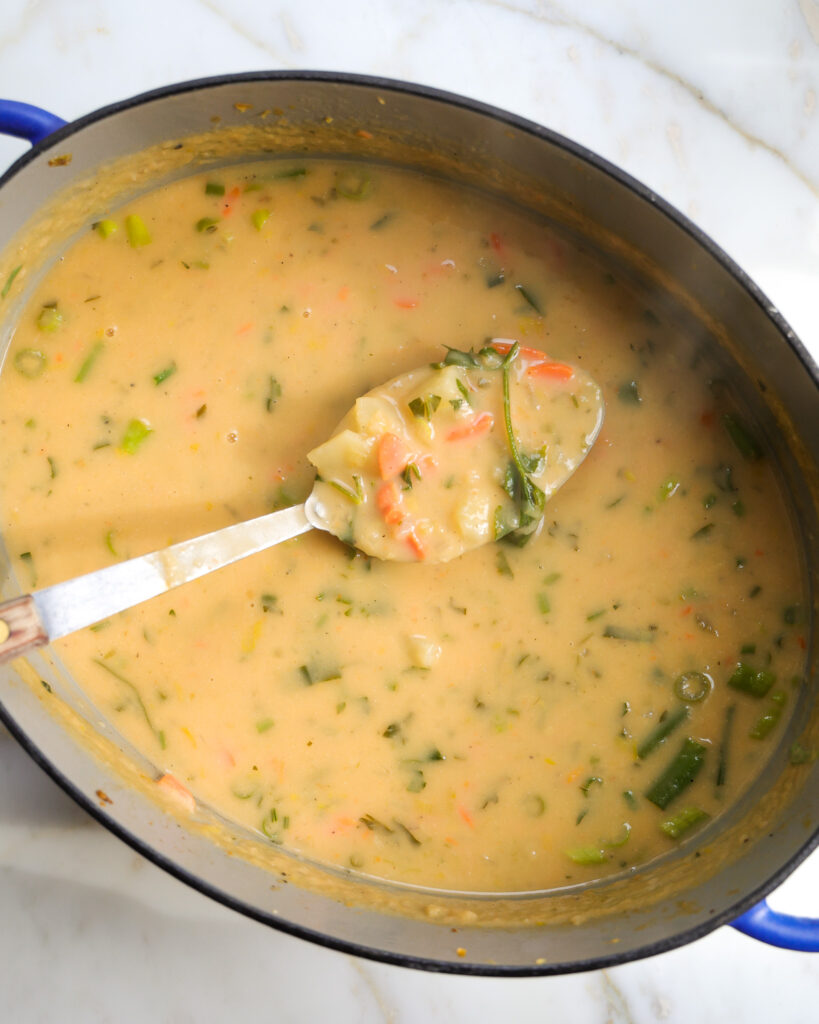 Potato soup being cooked in a dutch oven. 