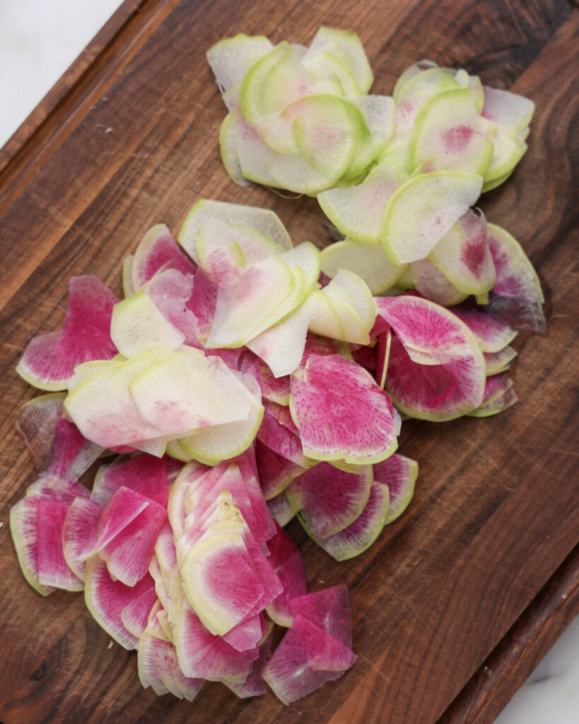 watermelon radishes sliced on a cutting board