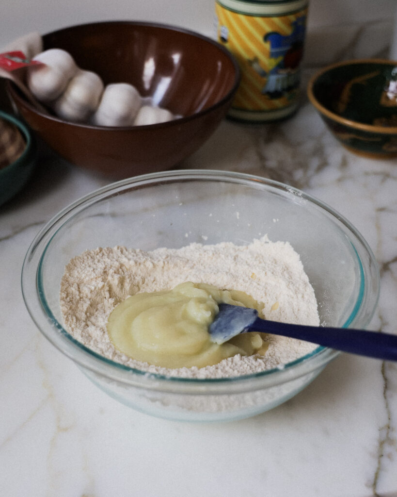 pureed cauliflower being mixed with dry ingredients.