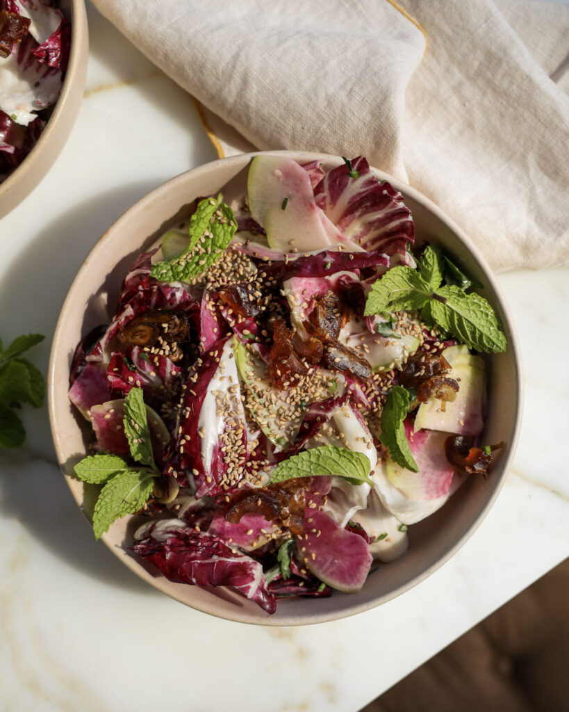 Lemon tahini salad topped with sesame seeds in a bowl.