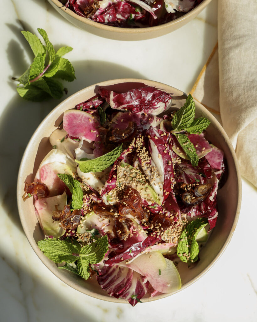Lemon tahini salad topped with sesame seeds in a bowl.