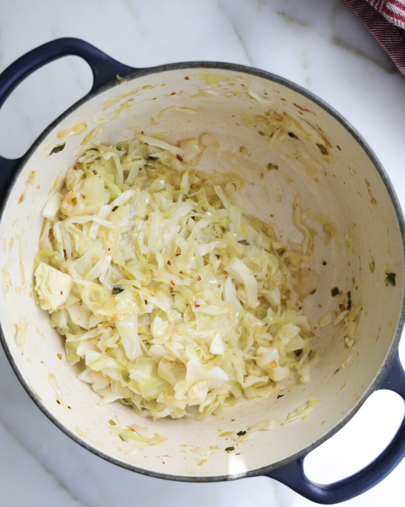 cabbage being cooked down in a Dutch oven.