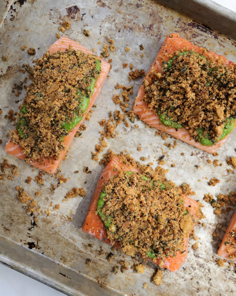 uncooked salmon topped with pesto and breadcrumbs.