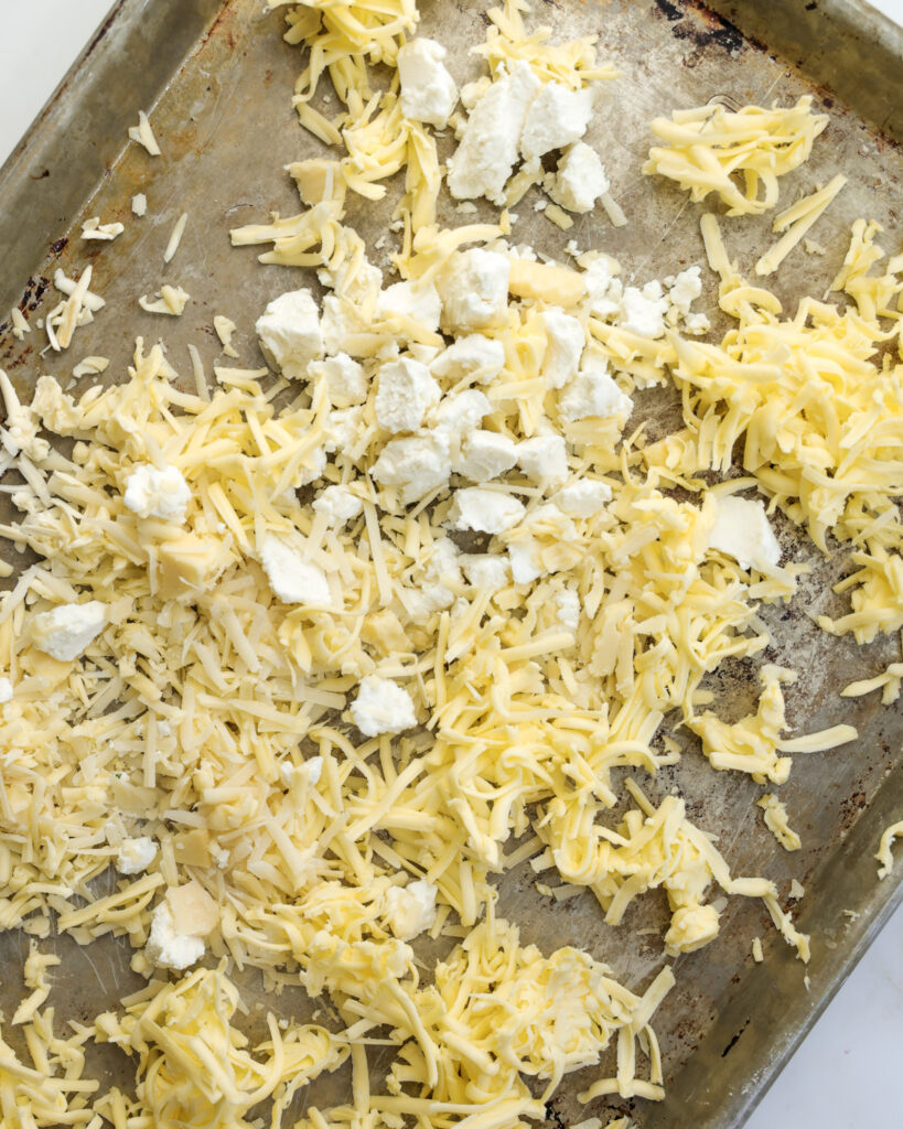 grated cheeses on a baking sheet.