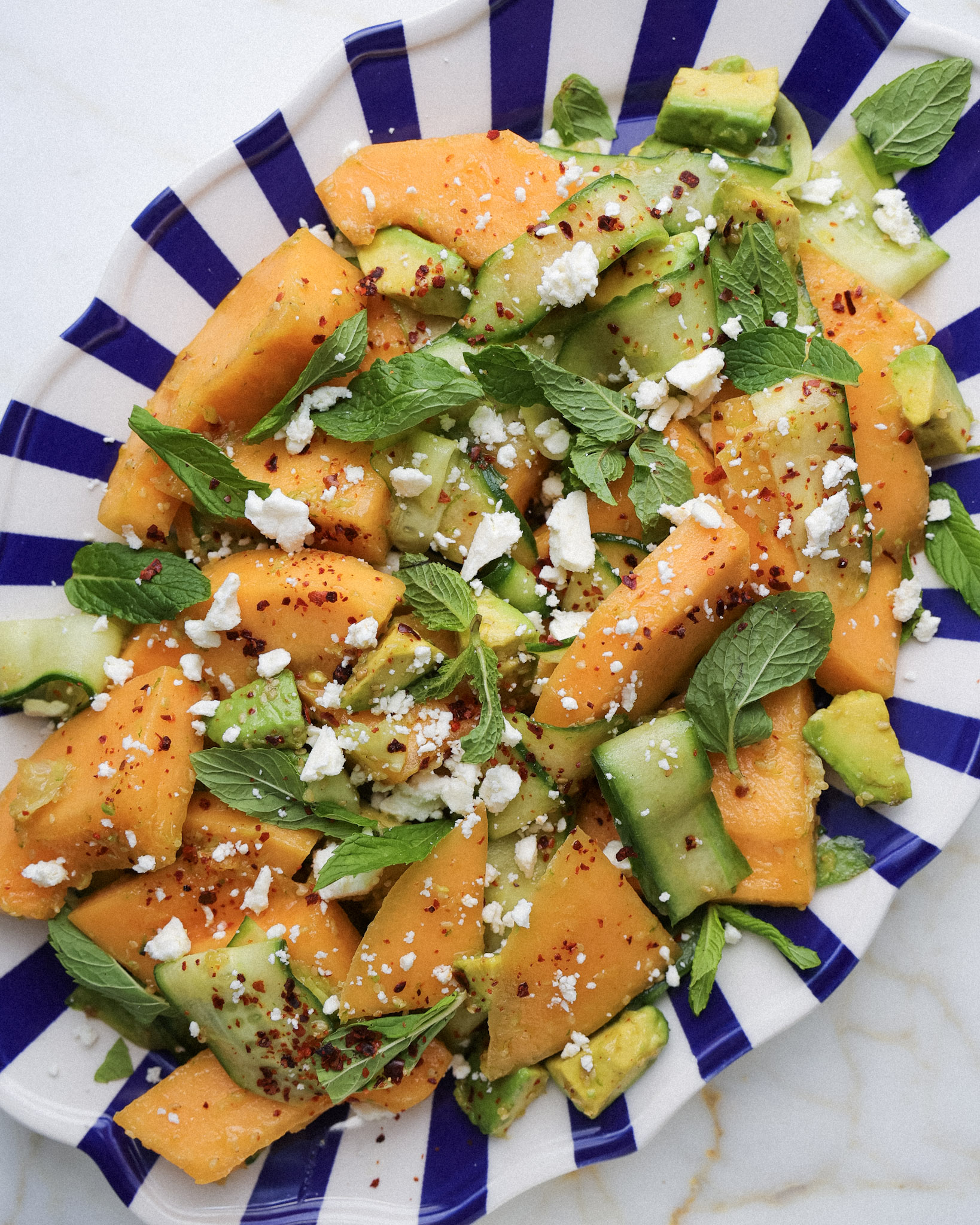 cucumber melon salad topped with mint and feta.