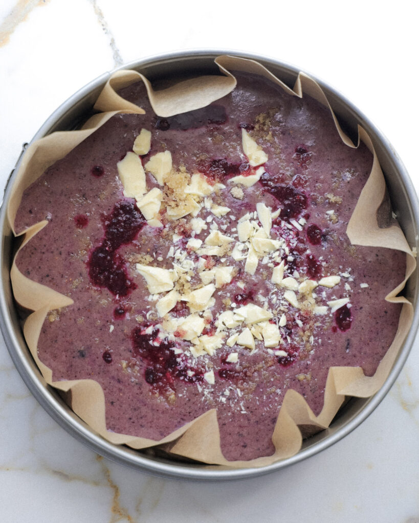 Blueberry brownies topped with white chocolate and blueberry puree.