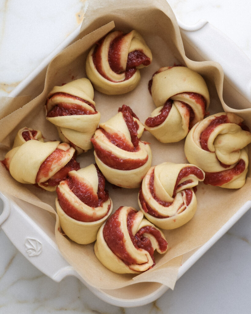 unbaked rhubarb rolls in a baking dish.