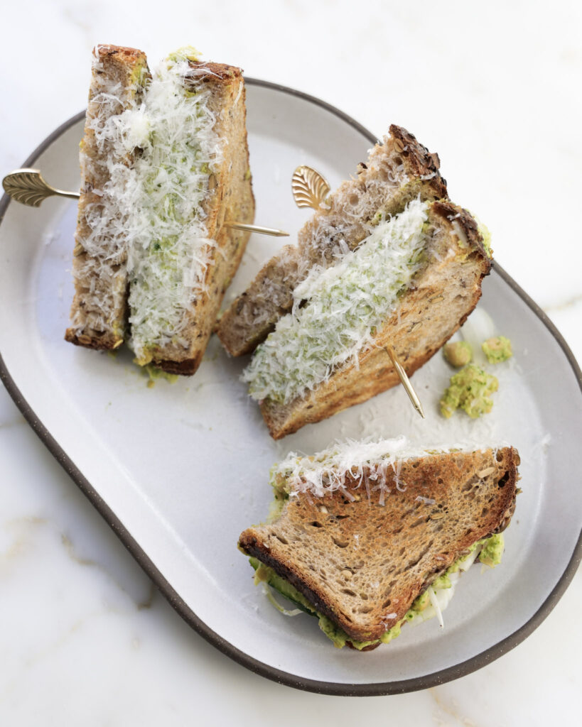 Chickpea salad sandwich cut in half and dipped in parmesan.