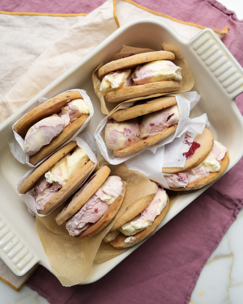 6 ice cream sandwiches wrapped in parchment paper.