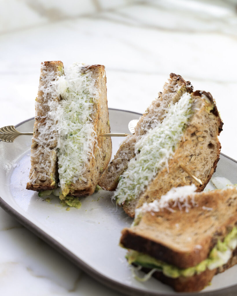 Chickpea salad sandwich cut in half and dipped in parmesan.