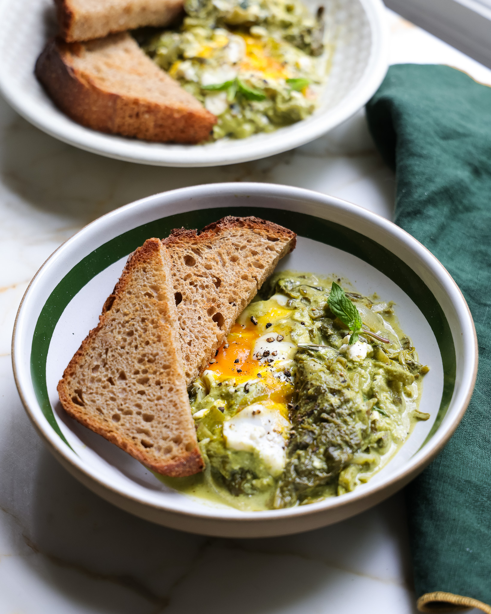 spring greens shakshuka in a cast iron skillet.