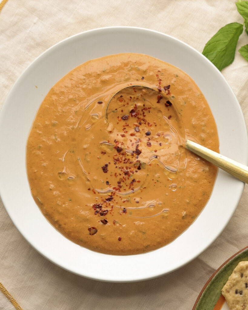 Romesco in a bowl topped with red pepper flakes and oil.